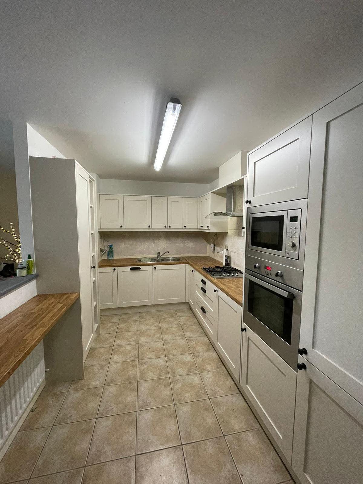 Fitted cream shaker kitchen with solid oak worktops, larder cupboard and integrated ovens