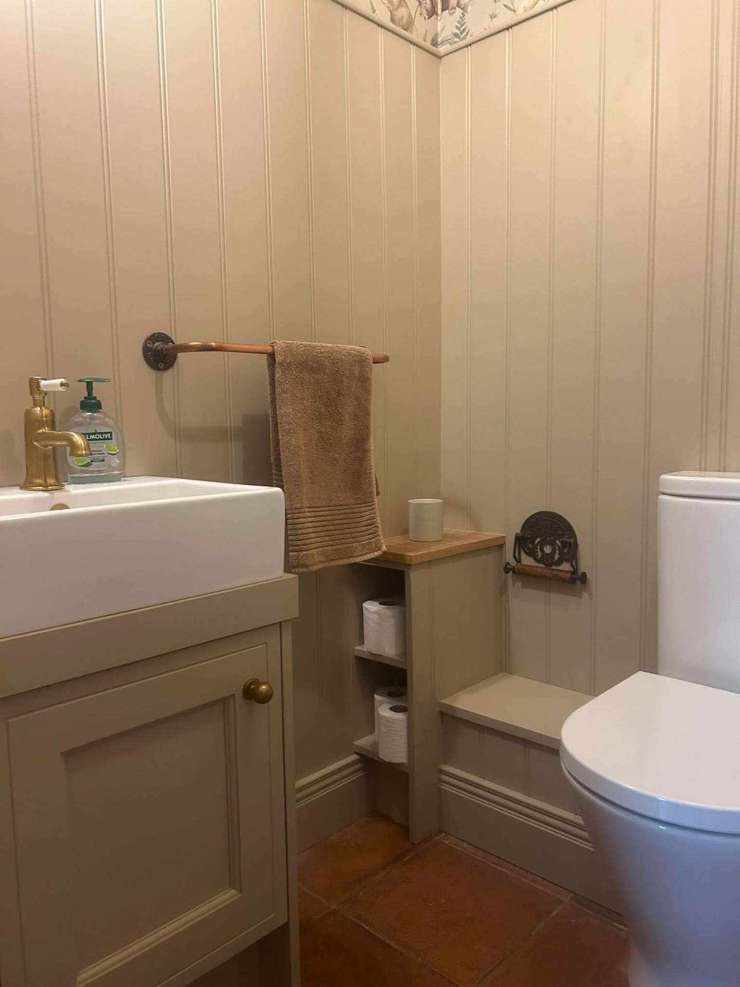 Beadboard panelled downstairs bathroom with painted shaker vanity, belfast sink, brass tap and bespoke slim storage between vanity and WC